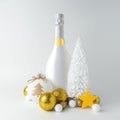 Creative Christmas composition with white champagne bottle and golden Christmas decoration. Minimal Christmas or New Year concept Royalty Free Stock Photo