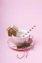Creative Christmas layout with cup, ginger house and candy cane on pink pastel color background