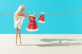 Creative Christmas layout with a doll wearing a towel and a clean red Santa Claus suit and hat against a light blue background. Royalty Free Stock Photo