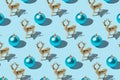 Creative Christmas pattern made of Christmas ornament and gold reindeer on bright blue background. Minimal Christmas or New Year Royalty Free Stock Photo