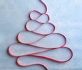 Creative Christmas tree made from red ribbon on blue background Royalty Free Stock Photo