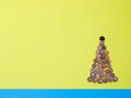 Creative Christmas tree made of seashells on modern yellow blue paper background Royalty Free Stock Photo