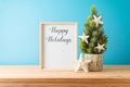 Creative Christmas tree with starfish decoration and frame mock up on wooden table over blue background Royalty Free Stock Photo