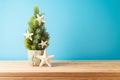 Creative Christmas tree with starfish decoration on wooden table over blue background Royalty Free Stock Photo