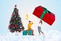 Creative collage picture of two excited mini people huge newyear giftbox decorated evergreen tree isolated on festive Royalty Free Stock Photo