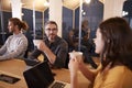 Creative colleagues drinking coffee and talking in their office canteen, close up, selective focus Royalty Free Stock Photo