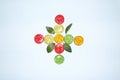 Creative colorful concept made of candy and leaves isolated on blue background .Fruit comcept