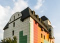 Creative colorful exterior of the commercial lowrise townhouse building architecture with a ventilate facade and loft mansard roof