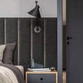 Creative composition of bedroom minimalistic interior details. Side table, design lamp, bedroom textiles and elegant accessories.