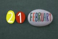 21 February, calendar date composed with colored and carved stones over green sand