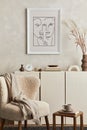 Creative composition of cozy living room interior design with mock up poster frame, fluffy armchair, coffee table, commode.