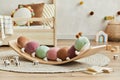 Creative composition of cozy scandi child`s room interior with plush caterpillar on the balance board, wooden toys and textile.