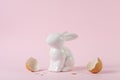 Creative composition with Easter bunny or rabbit with a broken egg shell. Minimal holiday concept Royalty Free Stock Photo