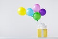 Creative composition with gift box and flying colorful balloons. Birthday or party concept