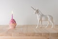 Creative composition with glitter unicorn and pink cupcake on wooden table. Minimal holiday concept