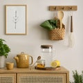 Creative composition of kitchen space with mock up poster frame, rattan commode, pitcher, herbs, vegetables, lemon, banana peach, Royalty Free Stock Photo