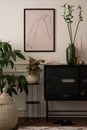 Creative composition of living room interior with mock up poster frame, black sideboard, glass vase with leaves, plants in Royalty Free Stock Photo