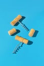 Creative composition made of wine bottle corks and corkscrews on blue background. Party drink concept Royalty Free Stock Photo