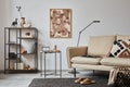 Creative composition of modern living room interior with mock up poster frame, beige sofa, side table, metal shelf. Copy space. Royalty Free Stock Photo