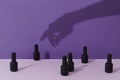 Creative composition with shadow of womans hand touch bottle of nail varnish over purple table Royalty Free Stock Photo