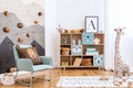 Creative composition of stylish and cozy child room interior design with eucalyptus wall, plush toys, furniture and accessories. P Royalty Free Stock Photo