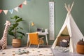 Creative composition of stylish and cozy child room interior design with green wall, plush toys, bright carpet, orange armchair, Royalty Free Stock Photo