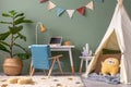 Creative composition of stylish and cozy child room interior design with green wall, plush toys, bright carpet, blue armchair,