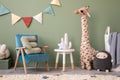 Creative composition of stylish and cozy child room interior design with green wall, plush toys, bright carpet, blue armchair,