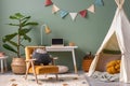 Creative composition of stylish and cozy child room interior design with green wall, plush toys, plant in basket; lamp, bright Royalty Free Stock Photo