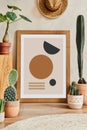 Creative composition of stylish living room interior with mock up poster frame, cacti and personal accessories. Plant love.