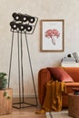 Creative composition of stylish living room interior with mock up poster frame, orange sofa, industrial lamp, coffee table.