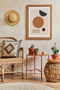 Creative composition of stylish living room interior with mock up poster frame, rattan armchair, coffee table, cacti and personal.