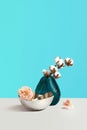 Creative composition with vase, flower and decorative cotton on grey table against blue background with space for design. Flower Royalty Free Stock Photo