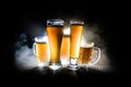 Creative concept. Beer glasses on wooden table at dark toned foggy background Royalty Free Stock Photo