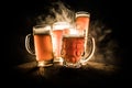 Creative concept. Beer glasses on wooden table at dark toned foggy background Royalty Free Stock Photo