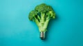 Creative concept of broccoli resembling light bulb on blue background Royalty Free Stock Photo
