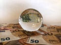 Crystal ball and large denomination euro banknotes. Royalty Free Stock Photo