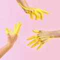 Creative concept of a raised hands dipped in yellow paint in the air. Pastel pink background