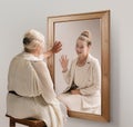Creative conceptual collage. Tender image of senior woman looking in mirror and smiling to her young self reflection