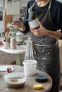 Creative woman is engaged in manufacture of handmade ceramics standing near table in pottery studio Royalty Free Stock Photo