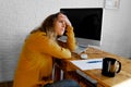 Tired and upset young woman sitting at the office desk.