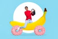 Creative 3d artwork photo collage of young smiling girl drive steering wheel banana car with donuts circles isolated on