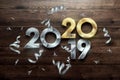 Creative design, Happy New Year, Metallic and gold numbers. Year 2019 is changing to 2020 Design on a wooden background. Merry Royalty Free Stock Photo