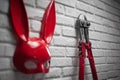 Creative design of refractory brick wall with the Bunny mask and the bolt cutters with a tight chain