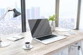 Creative designer desktop with empty laptop computer in modern interior with window and bright city view. Mock up Royalty Free Stock Photo