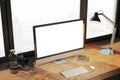 Creative designer desktop with empty white computer monitor, lamp, supplies and other items. Royalty Free Stock Photo