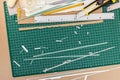 Creative desk with green cutting mat, cutter, pencil, tape, rule Royalty Free Stock Photo