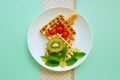 Creative dessert made of fruits and waffle. Funny breakfast for Kids. Food art. Lunch time. For tea. Royalty Free Stock Photo