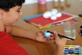 Creative development and screen-free leisure. A teenager painting colorful eggs for Easter decorations Royalty Free Stock Photo