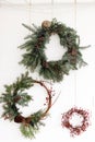 Creative different christmas wreaths with red berries and fir branches, isolated on white